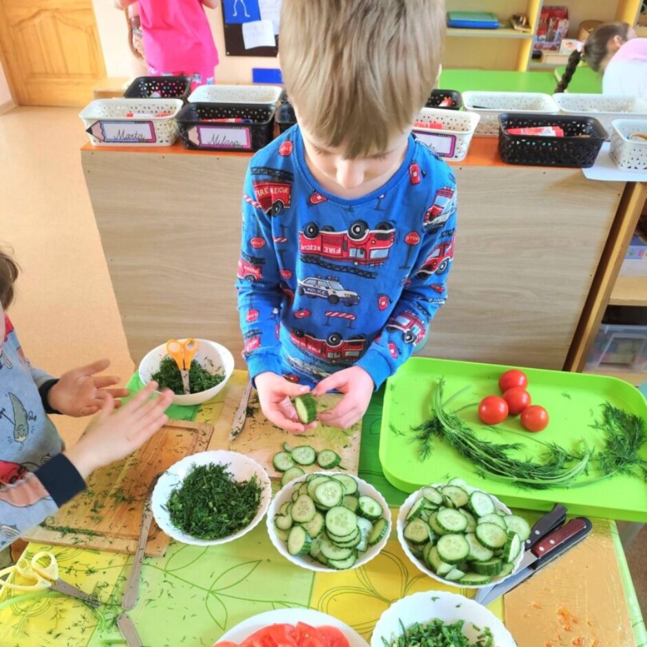 Zēns zilā kreklā ar ugunsdzēsēju mašīnām un uzrakstiem 