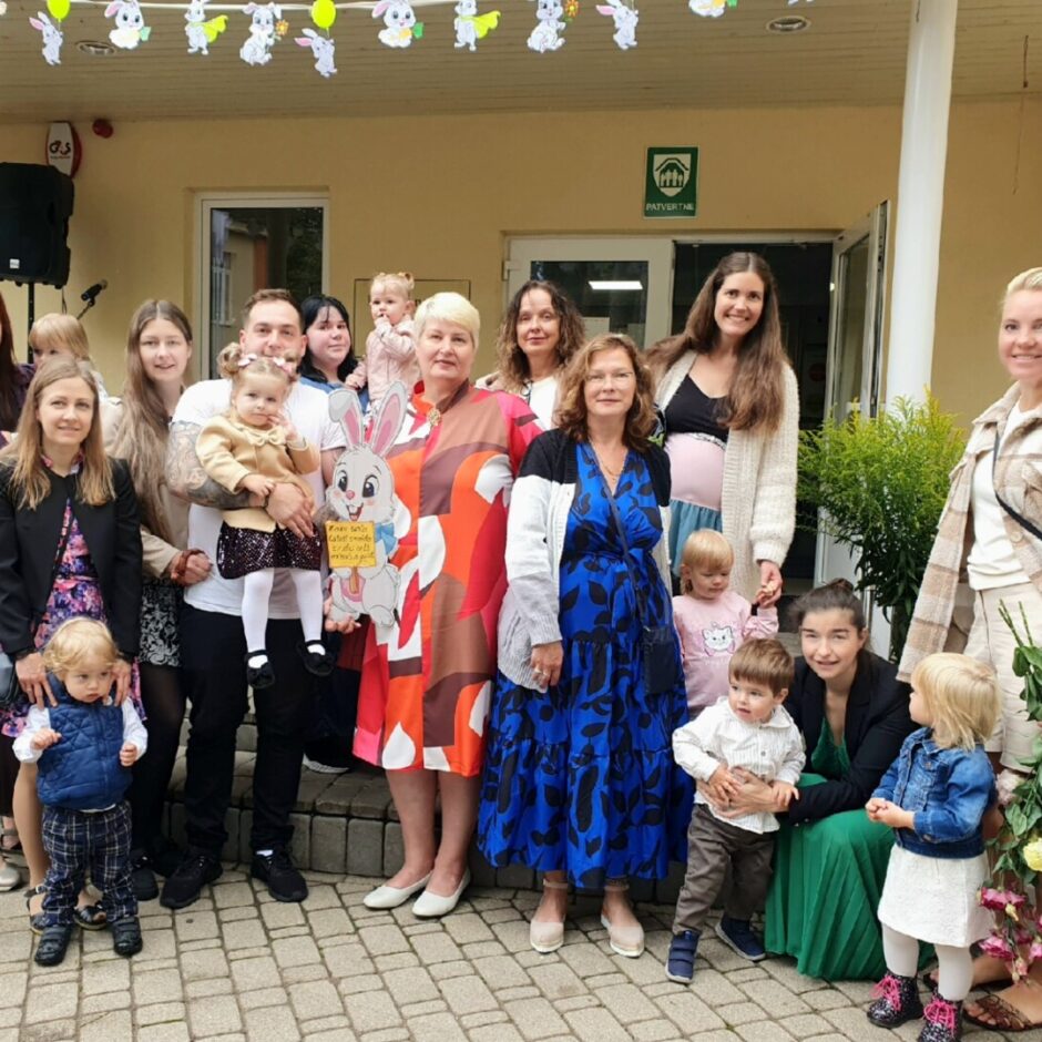 Cālīšu grupas un vecāku kopbilde pie skolas ēkas.