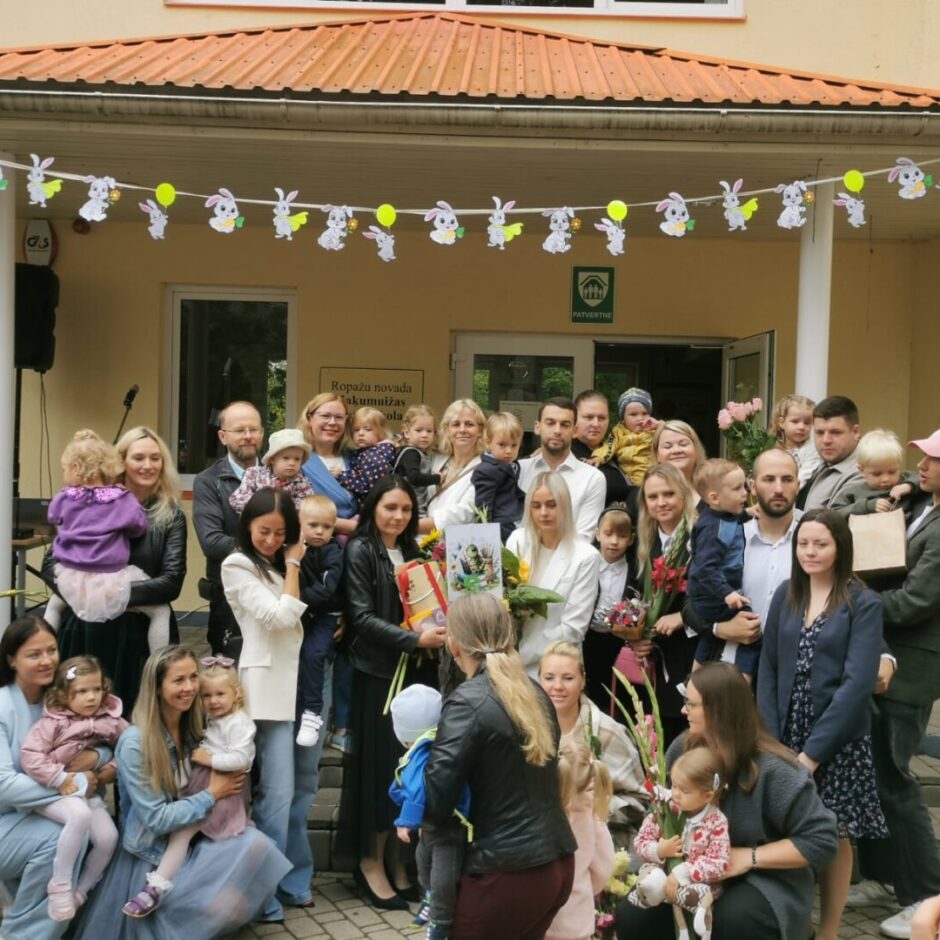 Sienāzīšu grupas un vecāku kopbilde pie skolas ēkas.